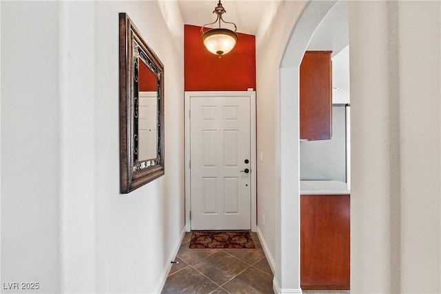 hall featuring dark tile patterned flooring