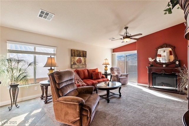 carpeted living room with ceiling fan, a wealth of natural light, and lofted ceiling