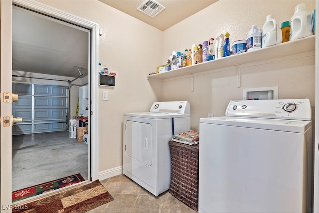 washroom featuring washer and clothes dryer and light tile patterned flooring