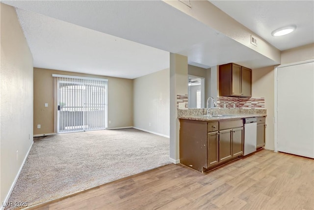 kitchen with ceiling fan, light colored carpet, dishwasher, decorative backsplash, and sink