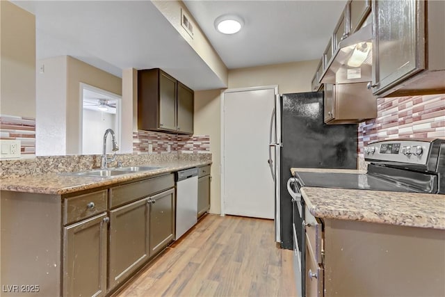 kitchen featuring ceiling fan, stainless steel appliances, decorative backsplash, light hardwood / wood-style flooring, and sink