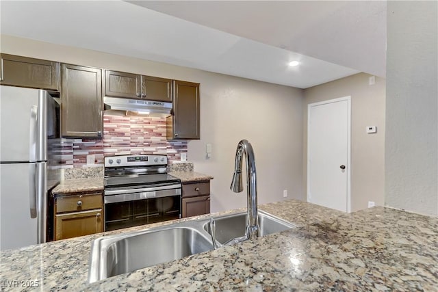 kitchen featuring sink, appliances with stainless steel finishes, decorative backsplash, and light stone countertops