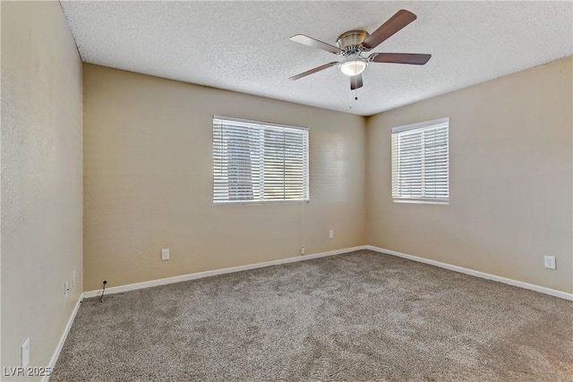 carpeted spare room with ceiling fan, a wealth of natural light, and a textured ceiling