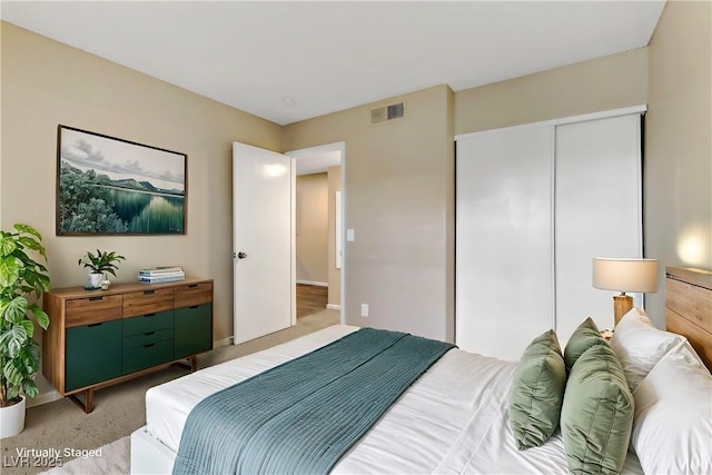 bedroom with light carpet and a closet