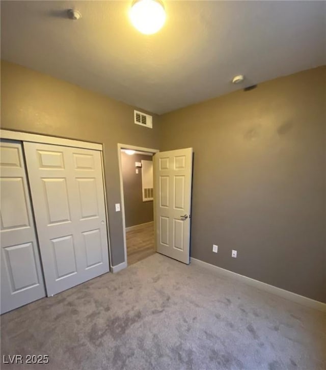 unfurnished bedroom featuring light carpet and a closet