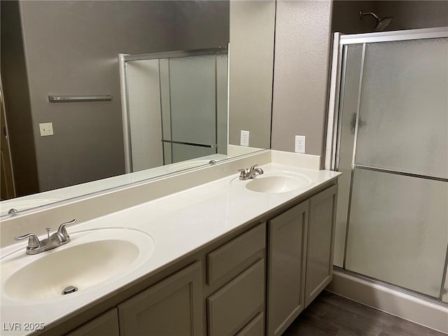 bathroom with hardwood / wood-style flooring, an enclosed shower, and vanity