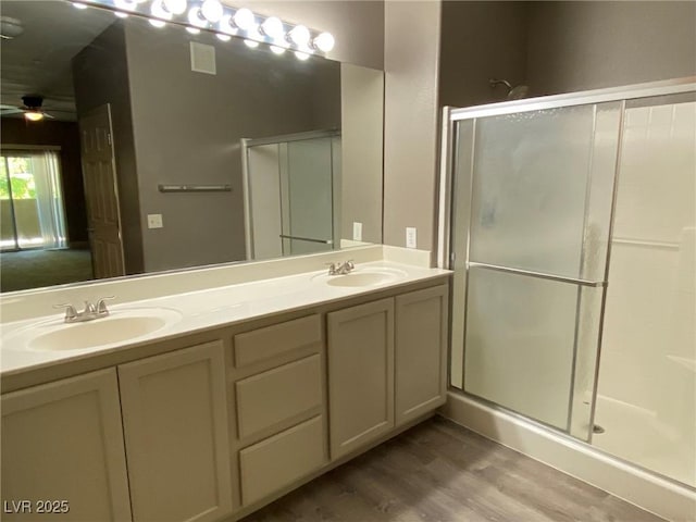 bathroom with ceiling fan, vanity, a shower with door, and hardwood / wood-style flooring