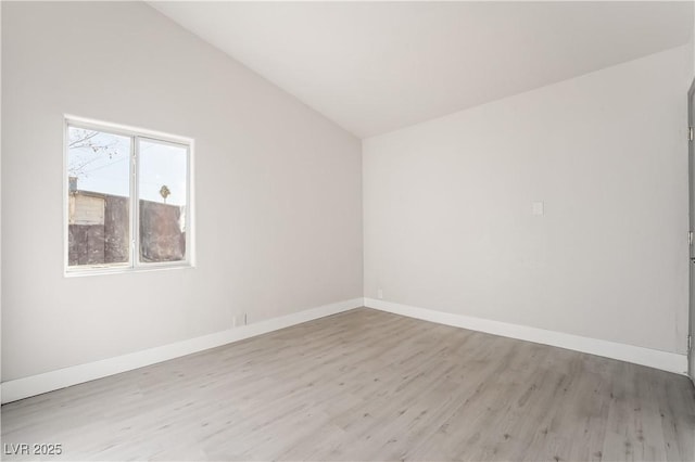 unfurnished room with light hardwood / wood-style flooring and lofted ceiling