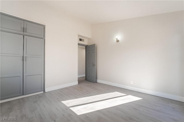 unfurnished bedroom with a closet and light hardwood / wood-style flooring