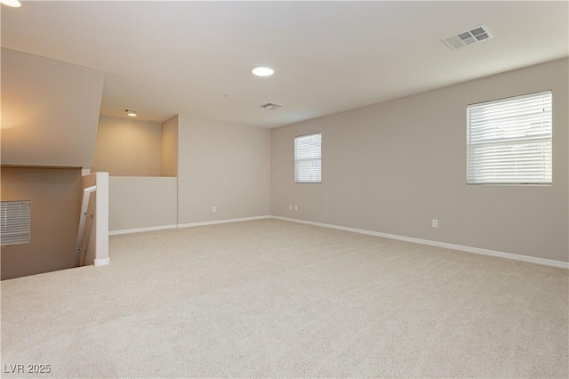 carpeted spare room featuring baseboards, visible vents, and recessed lighting