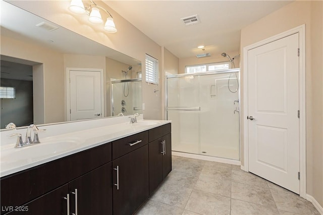 bathroom featuring double vanity, a sink, visible vents, and a shower stall