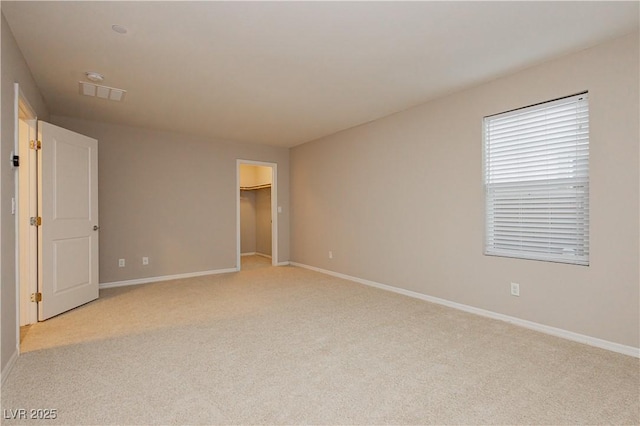 spare room with light carpet, visible vents, and baseboards