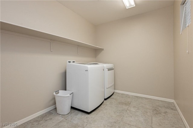 clothes washing area with laundry area, washing machine and dryer, and baseboards