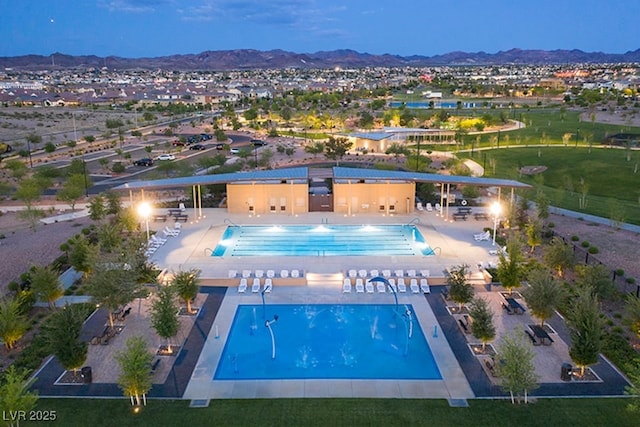 community pool with a patio area and a mountain view