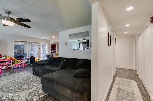 living room with ceiling fan, hardwood / wood-style floors, and a textured ceiling