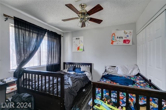 bedroom featuring ceiling fan, a closet, and a textured ceiling