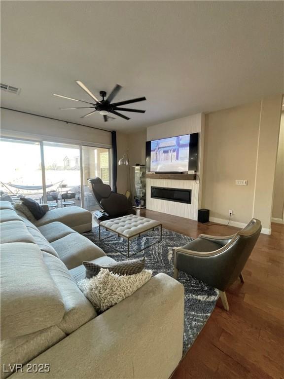 living room featuring ceiling fan and hardwood / wood-style floors