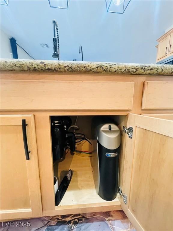 details with light brown cabinetry and light stone countertops