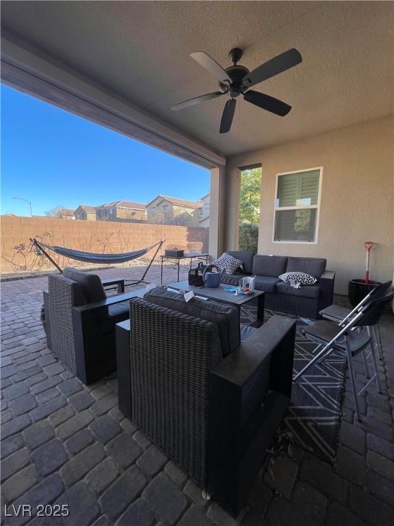 view of patio with an outdoor living space and ceiling fan