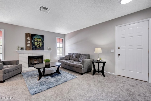 carpeted living room with a textured ceiling and a fireplace