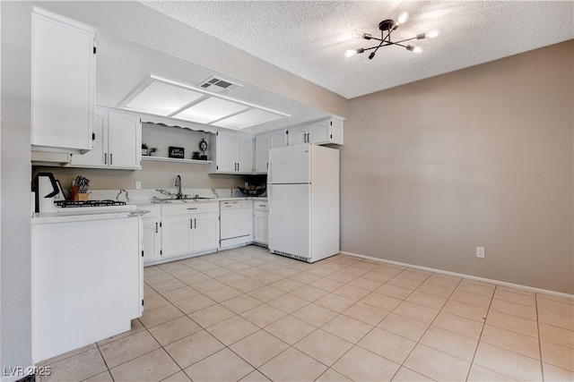 kitchen featuring sink, white appliances, white cabinetry, a textured ceiling, and light tile patterned floors