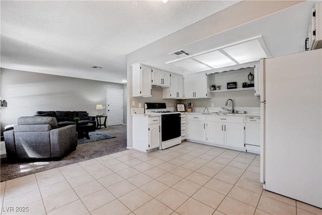 kitchen featuring a textured ceiling, sink, white cabinets, and white appliances