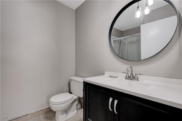 bathroom featuring toilet, tile patterned floors, vanity, and a shower with shower door