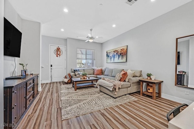 living room with light wood-type flooring and ceiling fan