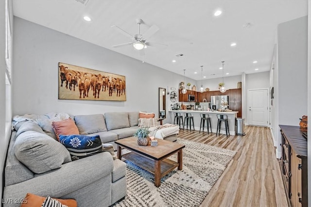 living room featuring light hardwood / wood-style floors and ceiling fan