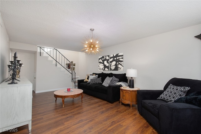 living room with a textured ceiling, dark hardwood / wood-style flooring, and a notable chandelier