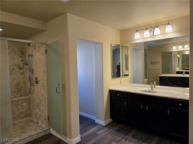 bathroom featuring walk in shower, vanity, and wood-type flooring