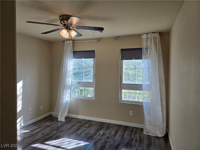 spare room featuring dark wood-type flooring and ceiling fan