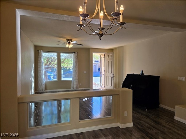 interior space featuring dark wood-type flooring and ceiling fan with notable chandelier