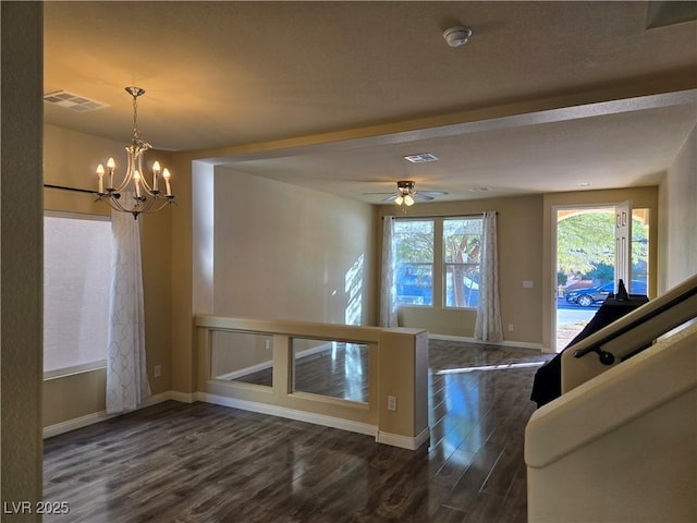 interior space with dark wood-type flooring and ceiling fan with notable chandelier