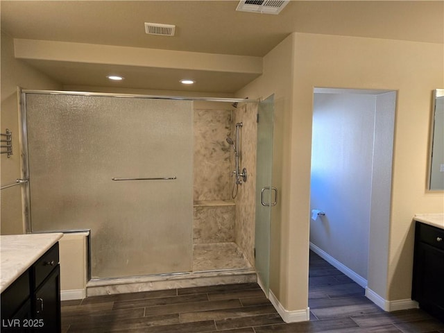 bathroom with walk in shower, hardwood / wood-style flooring, and vanity