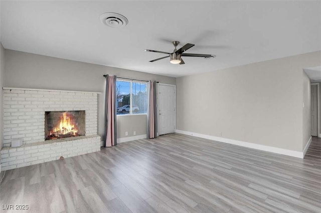 unfurnished living room with light hardwood / wood-style floors, ceiling fan, and a fireplace