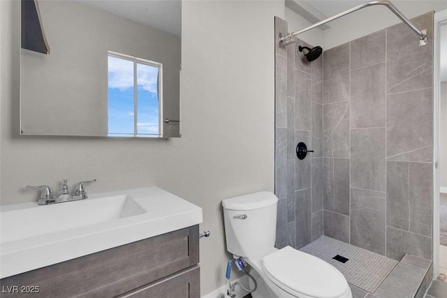 bathroom featuring toilet, a tile shower, and vanity