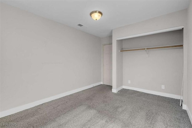 unfurnished bedroom with a closet and dark colored carpet