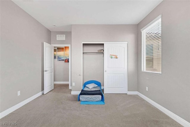 unfurnished bedroom with a closet, light colored carpet, and multiple windows