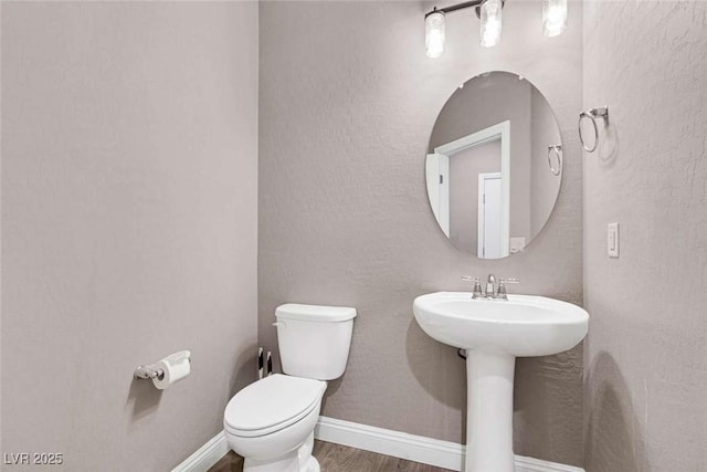 bathroom with toilet and hardwood / wood-style floors