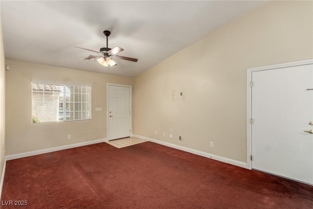 carpeted spare room featuring vaulted ceiling and ceiling fan