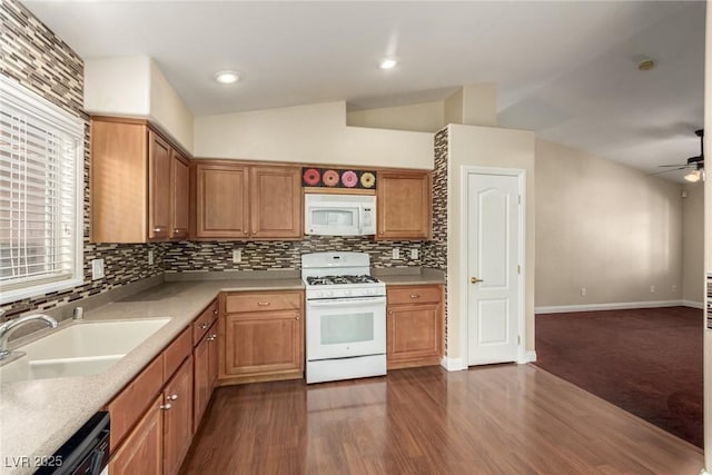 kitchen featuring vaulted ceiling, dark hardwood / wood-style flooring, sink, and white appliances