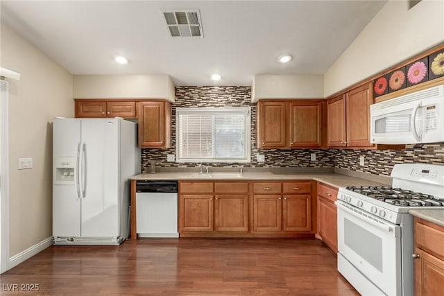 kitchen featuring dark wood-type flooring, sink, and white appliances