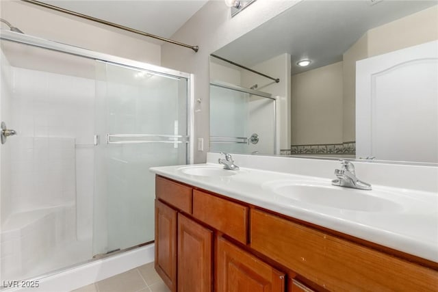 bathroom with an enclosed shower, vanity, and tile patterned flooring