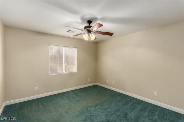 spare room featuring ceiling fan and dark colored carpet