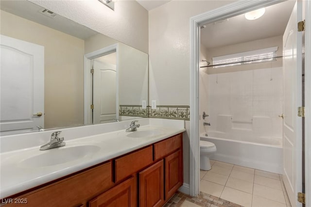 full bathroom with washtub / shower combination, toilet, vanity, and tile patterned flooring