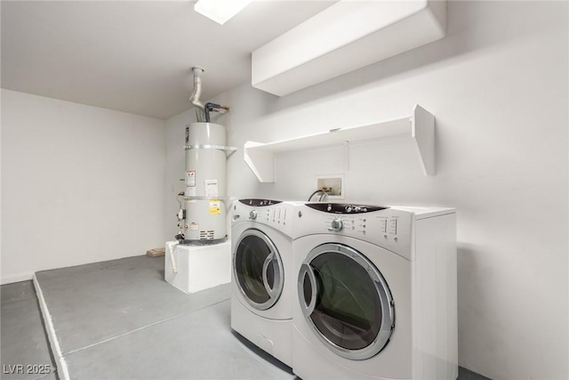 clothes washing area featuring strapped water heater and washing machine and clothes dryer