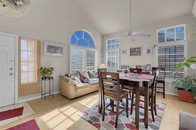 dining room featuring light hardwood / wood-style floors, high vaulted ceiling, and ceiling fan