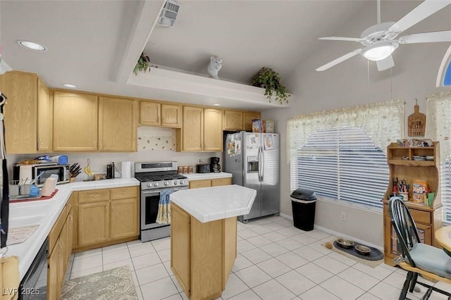 kitchen with a center island, light brown cabinets, stainless steel appliances, light tile patterned flooring, and ceiling fan