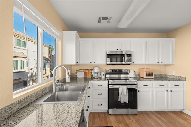 kitchen featuring light hardwood / wood-style floors, sink, stainless steel appliances, and white cabinetry